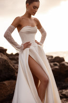 The Sarabi bridal gown featuring a structured bodice and daring thigh slit captures contemporary elegance and confidence.
