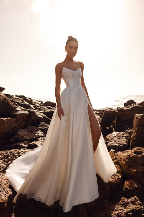 The Alya wedding gown features matte satin, a corset bodice and delicate straps, presenting minimalist elegance in the front.