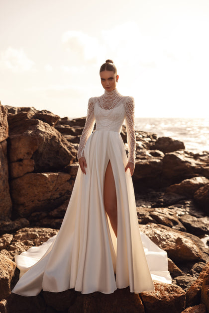 The high side slit in the Alya gown adds lightness and accentuates the leg, giving the style a bold yet elegant character.