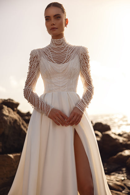 Alya bridal blouse with pearl long sleeves and high-slit skirt highlights a modern, luxurious bridal look.