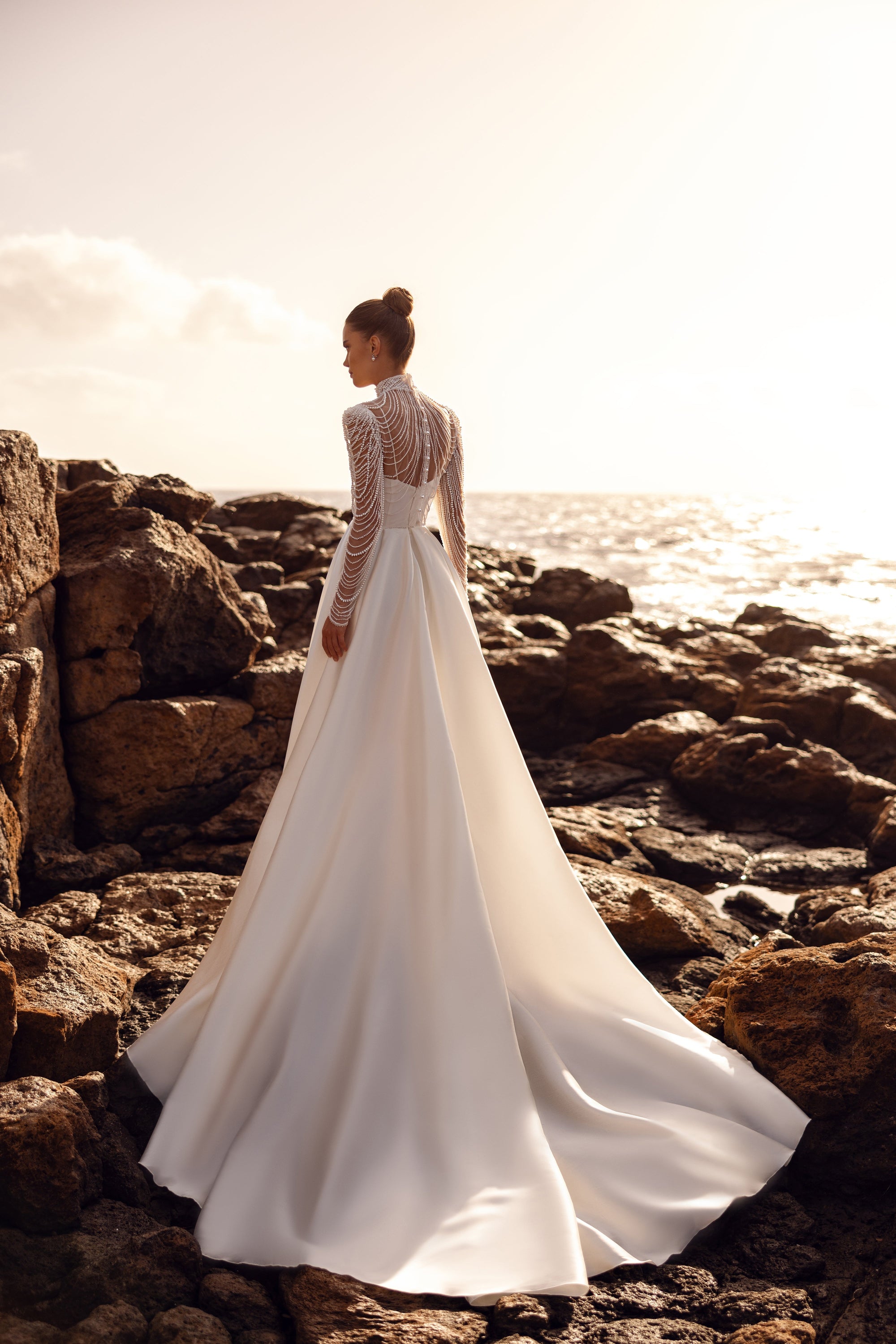 Alya bridal blouse with long pearl-embellished sleeves and a dramatic train creates a regal wedding look.