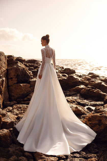 Alya bridal blouse with long pearl-embellished sleeves and a dramatic train creates a regal wedding look.