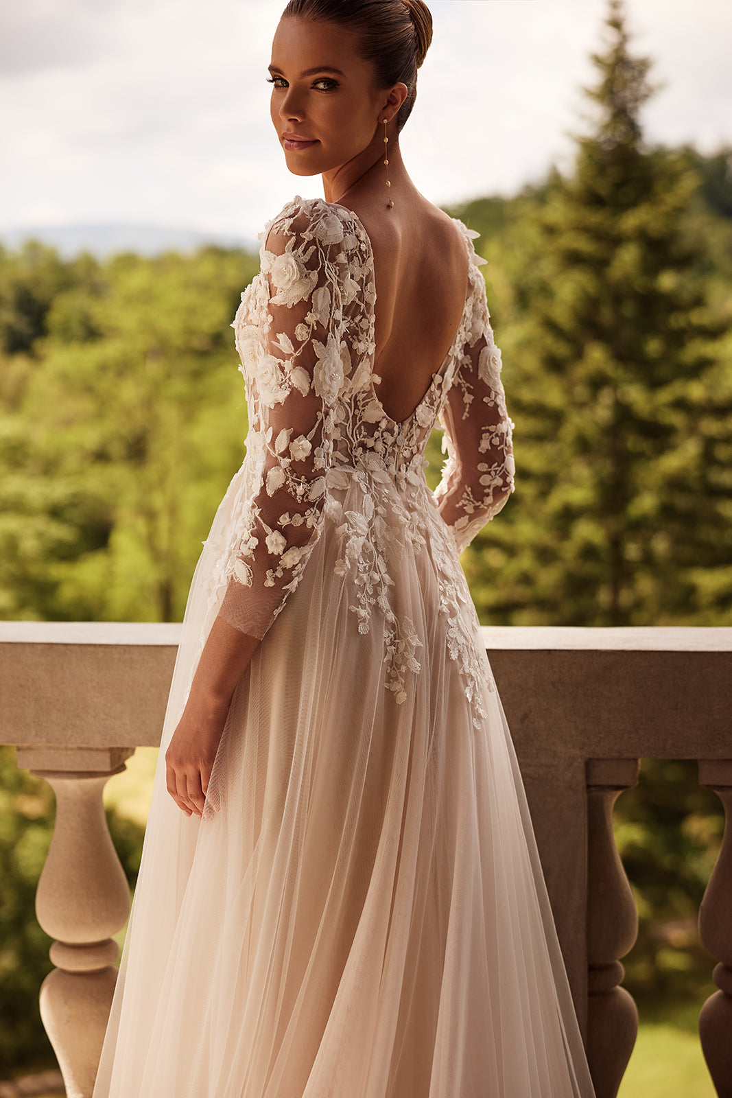Back view of Felicia wedding dress, with a deep open back and floral lace sleeves