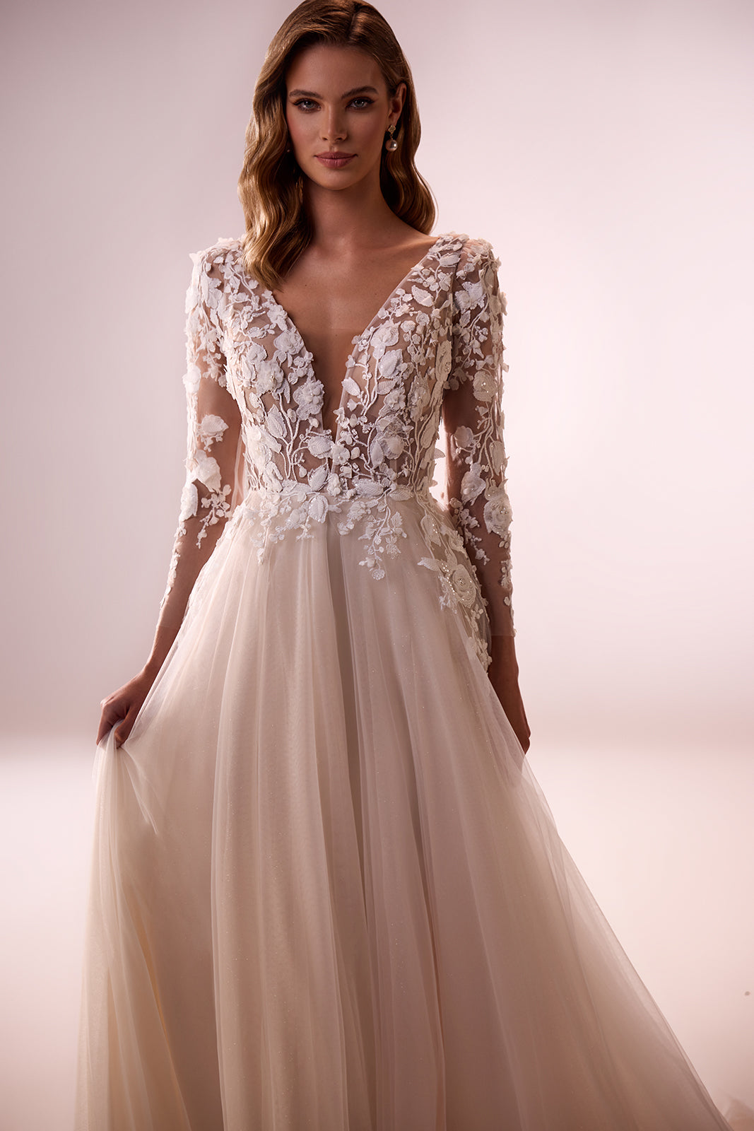 Felicia wedding dress in the studio, with 3D flowers on the bodice and long sheer sleeves