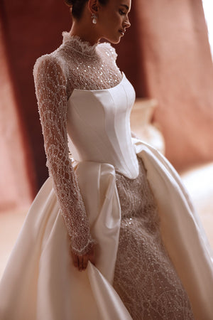 The Henriette overskirt with sparkling lace and satin train enhances the elegance of a contemporary bridal look.