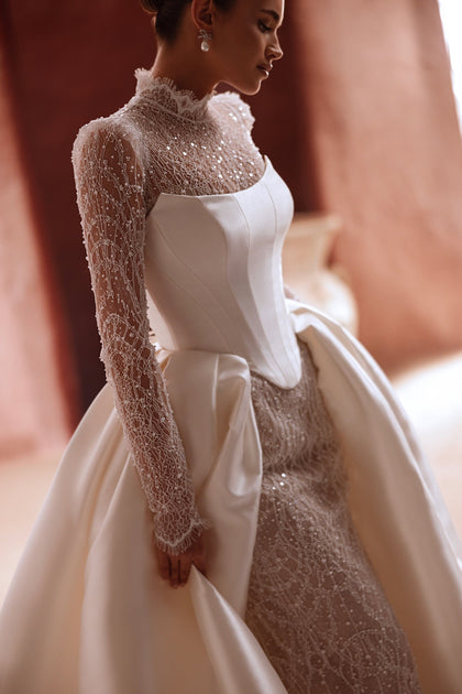 The Henriette overskirt with sparkling lace and satin train enhances the elegance of a contemporary bridal look.