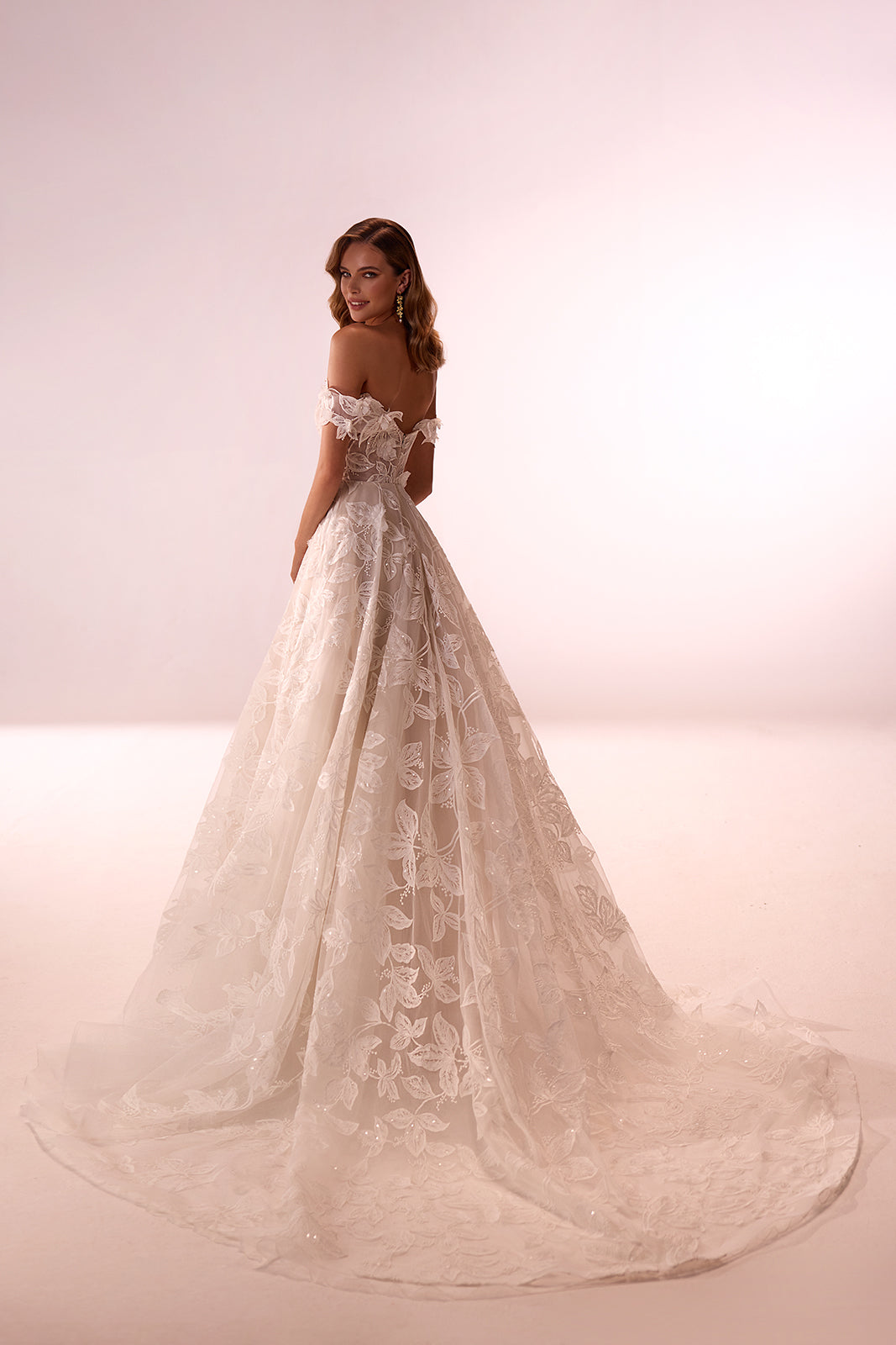Full-length studio back view of Ivy wedding dress, with a lace skirt and long train