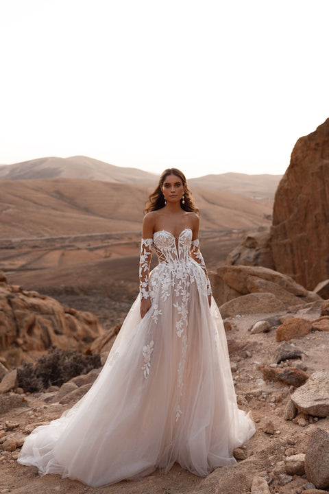 The Nabila bridal gown with a dramatic long veil and floral lace details offers a romantic fairytale look for modern brides.