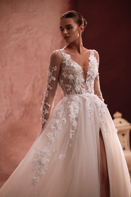The Semiramida gown by DAMA Couture features a sheer bodice embellished with floral embroidery and 3D appliqués — a romantic, ethereal vision.