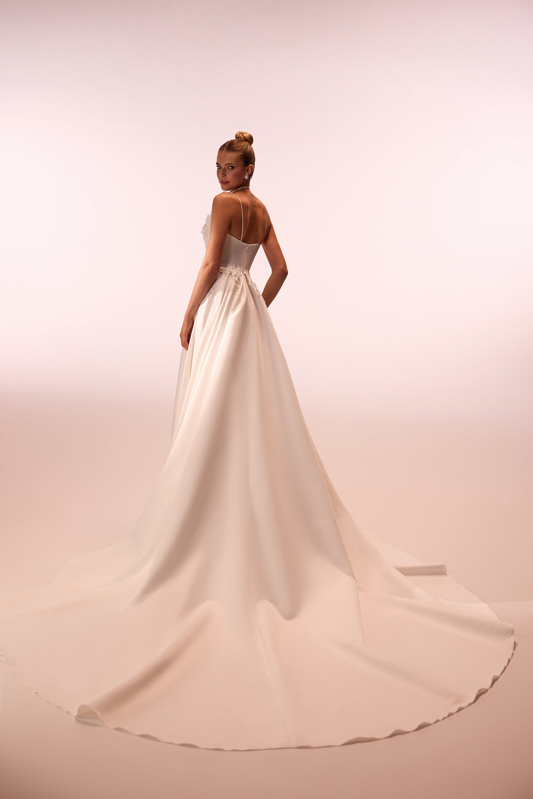 Full silhouette of Seraphine from behind in the studio, with a satin skirt