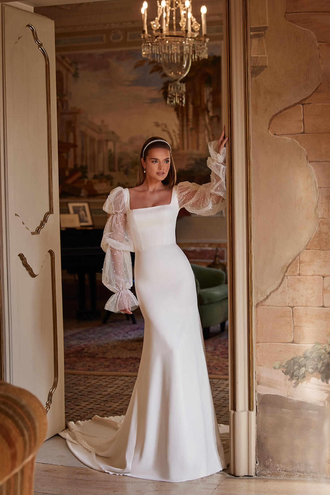 Clara wedding dress from the front in full length, with a smooth satin skirt and long sleeves