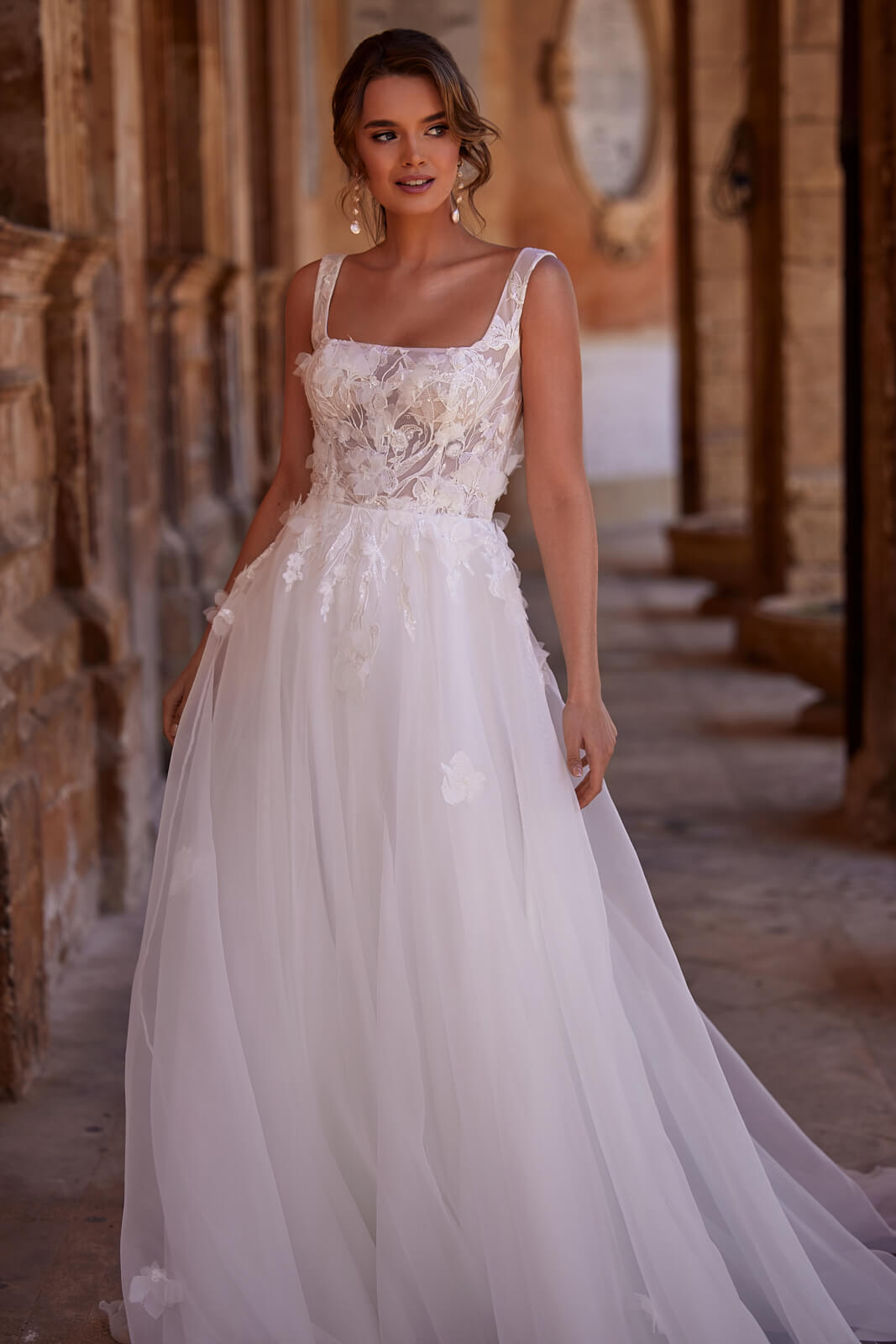 Lucy wedding dress from the front, with a square neckline and wide straps above the organza skirt