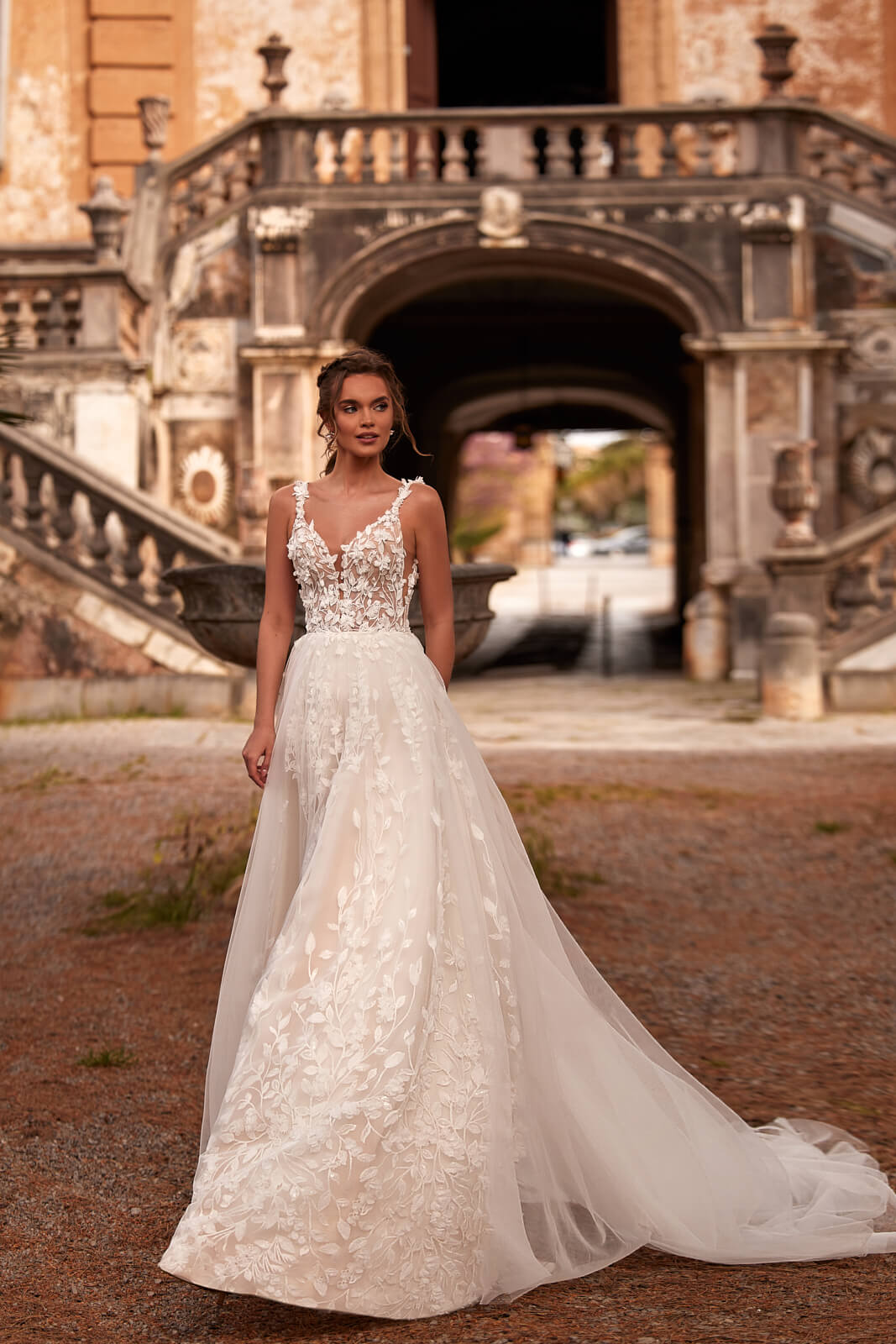 Full silhouette of Sanah outside a villa, with floral appliqués over tulle