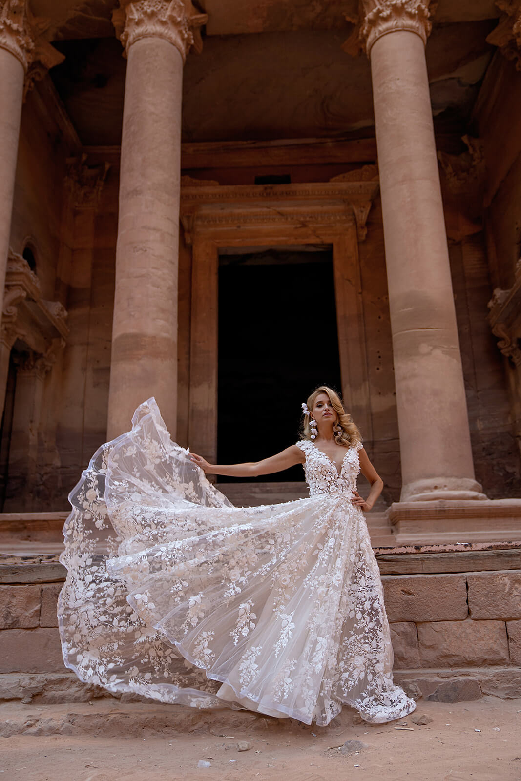 Full-length Azalea wedding dress beside an old façade, with the skirt swinging in motion