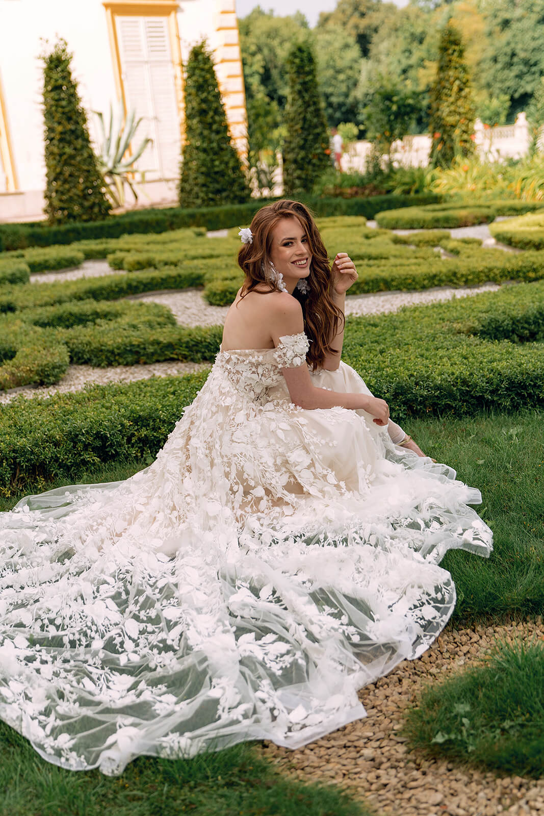 Azalea wedding dress on a garden path, with the train spread around the bride