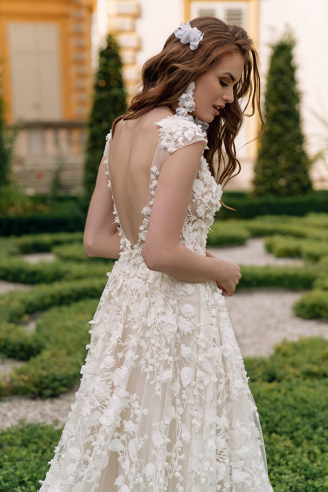 Back view of Azalea wedding dress in the garden, with lace framing the opening down to the waist