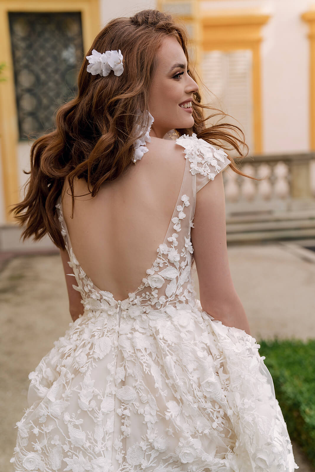Close-up of the deep open back and floral appliqués on Azalea wedding dress