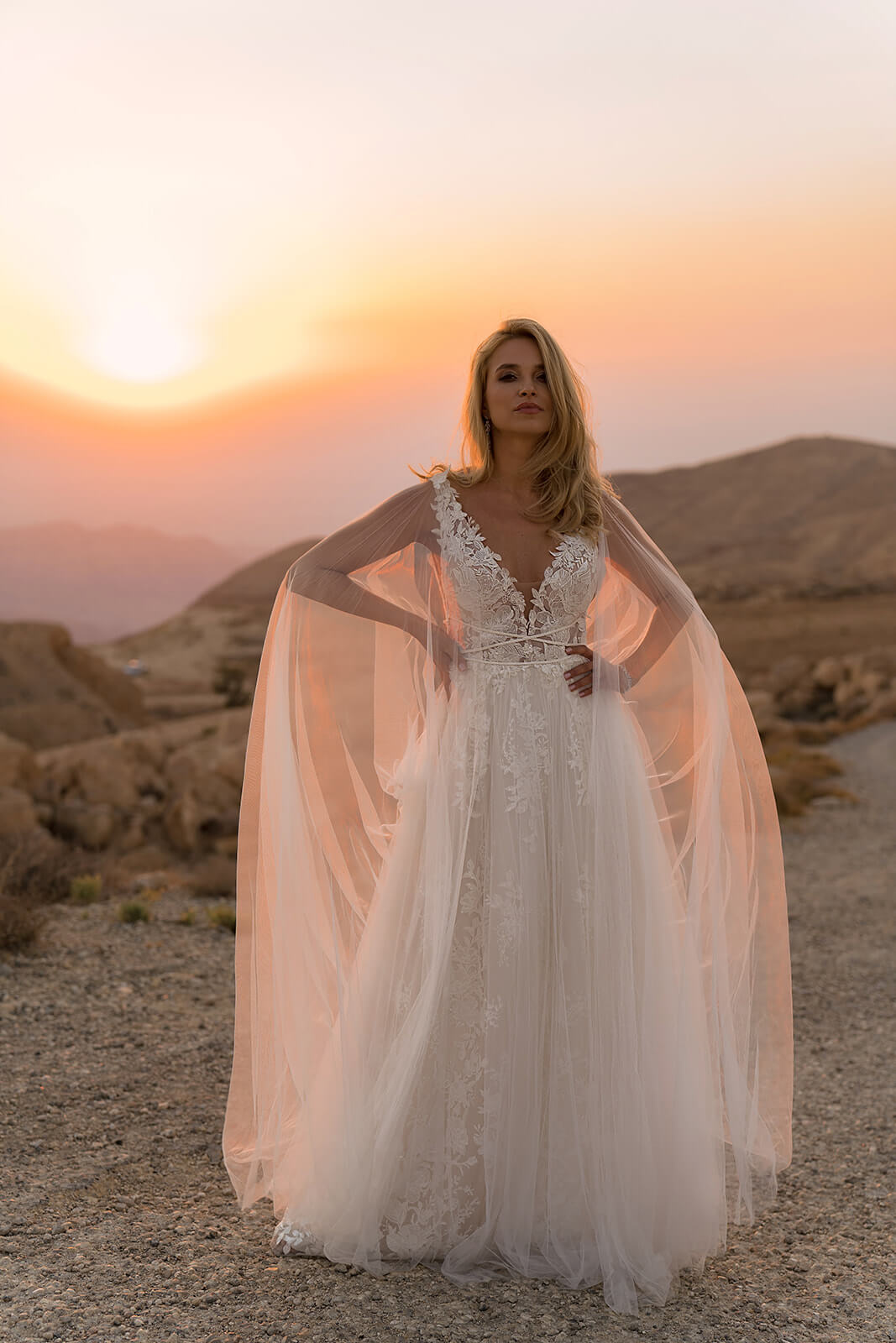 Full-length view of Linda wedding dress, with the tulle cape spread out on both sides
