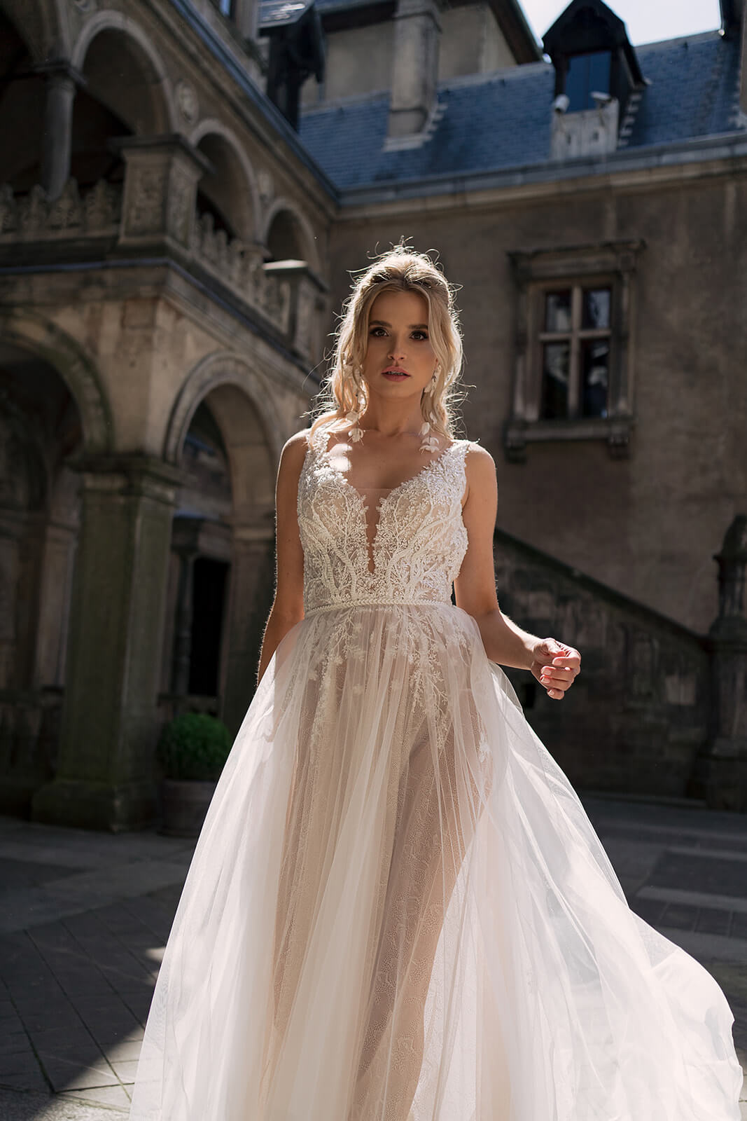 Sunlit front view of Livia A-line wedding dress, with a lace bodice above tulle