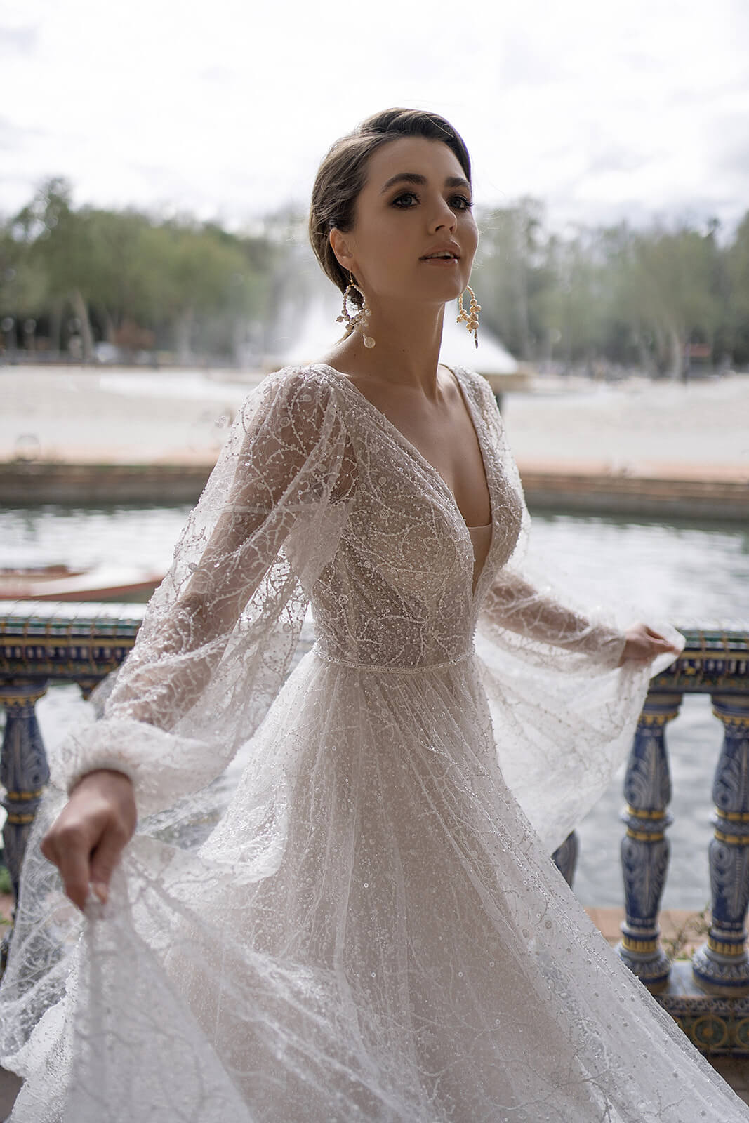 Suri at full length, an A-line gown of glitter tulle with floral lace