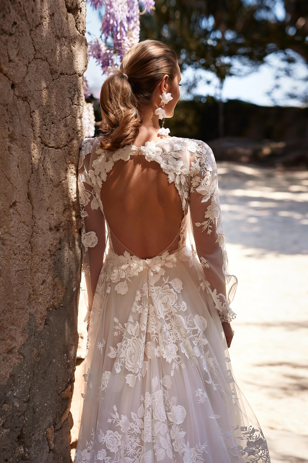Asami wedding dress from behind, with an open back and raised floral lace over tulle