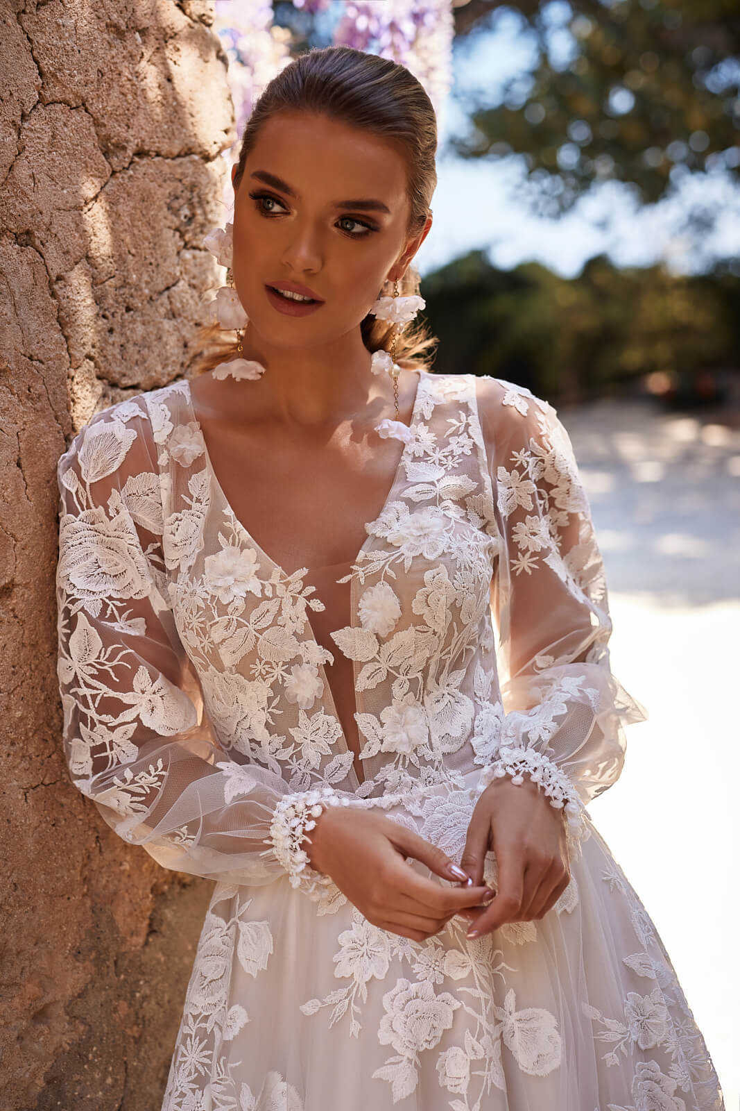 Close-up of Asami wedding dress, with a deep V neckline and sheer puffed lace sleeves