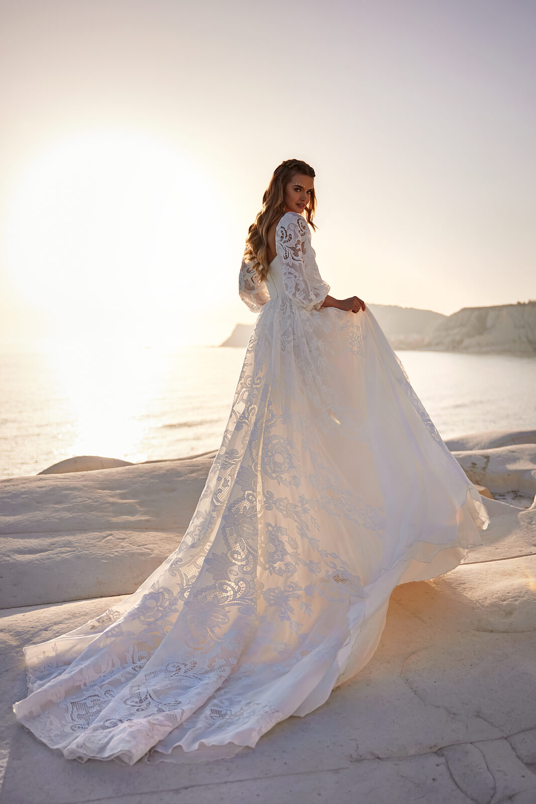 Rania in backlight, the skirt lifted to one side with the train behind