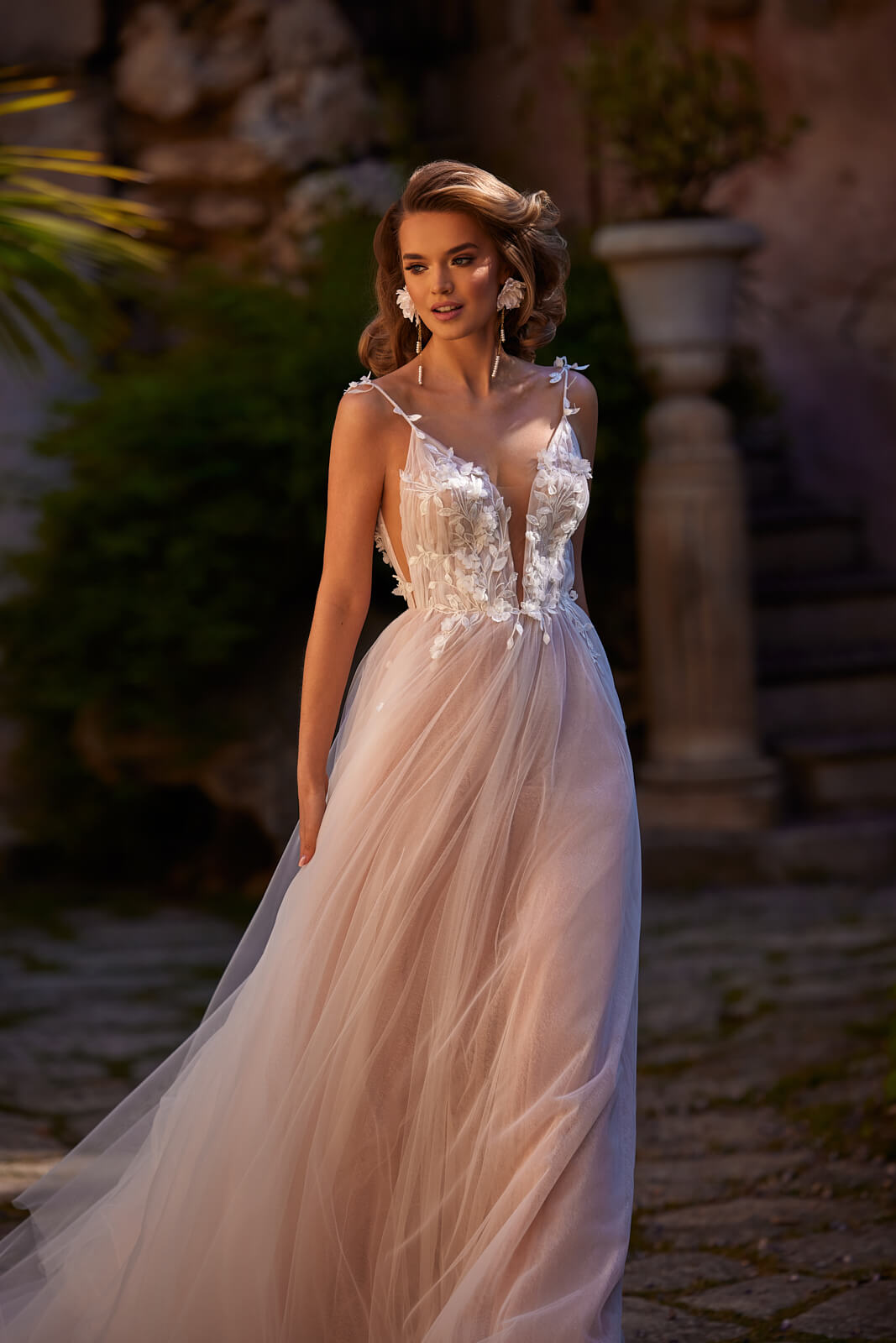 Sava in an A-line shape, with 3D flowers at the deep V above a tulle skirt