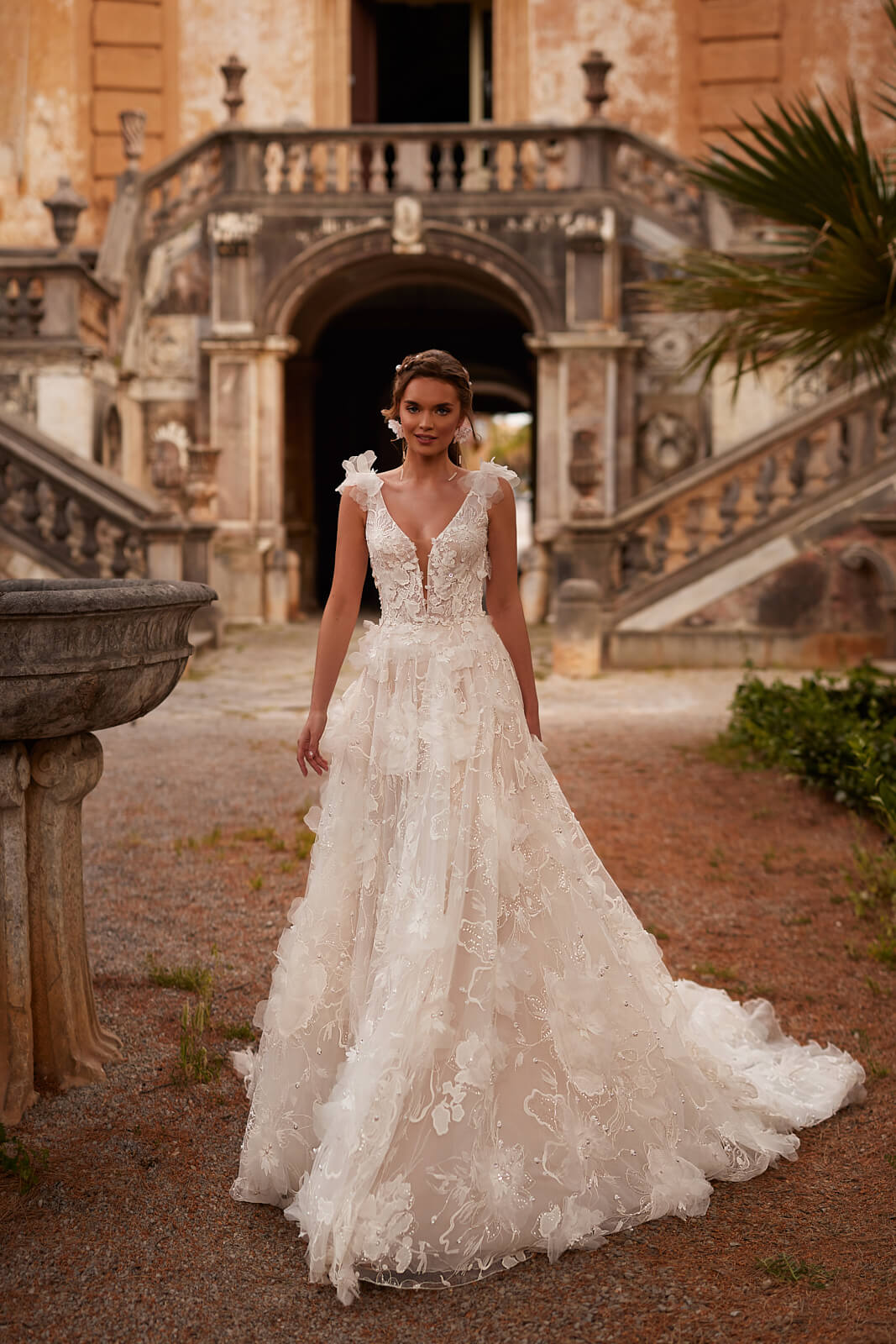 Full-length front view of Calanthe A-line wedding dress before an old villa