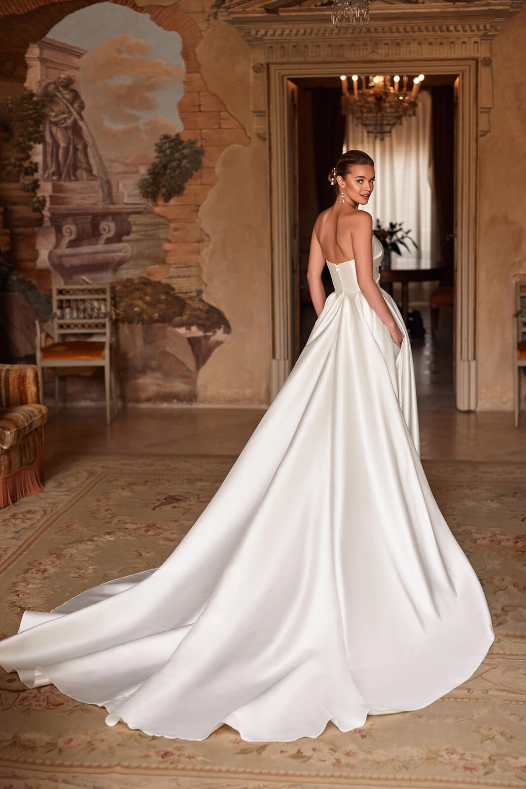 Madelaine wedding dress from behind, with a bare back and a wide satin train spread out