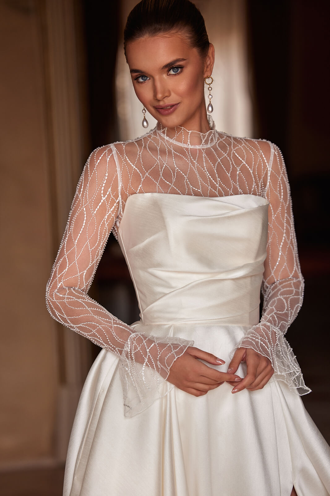 Close-up of Madelaine wedding dress with a beaded tulle top, high collar and long sleeves