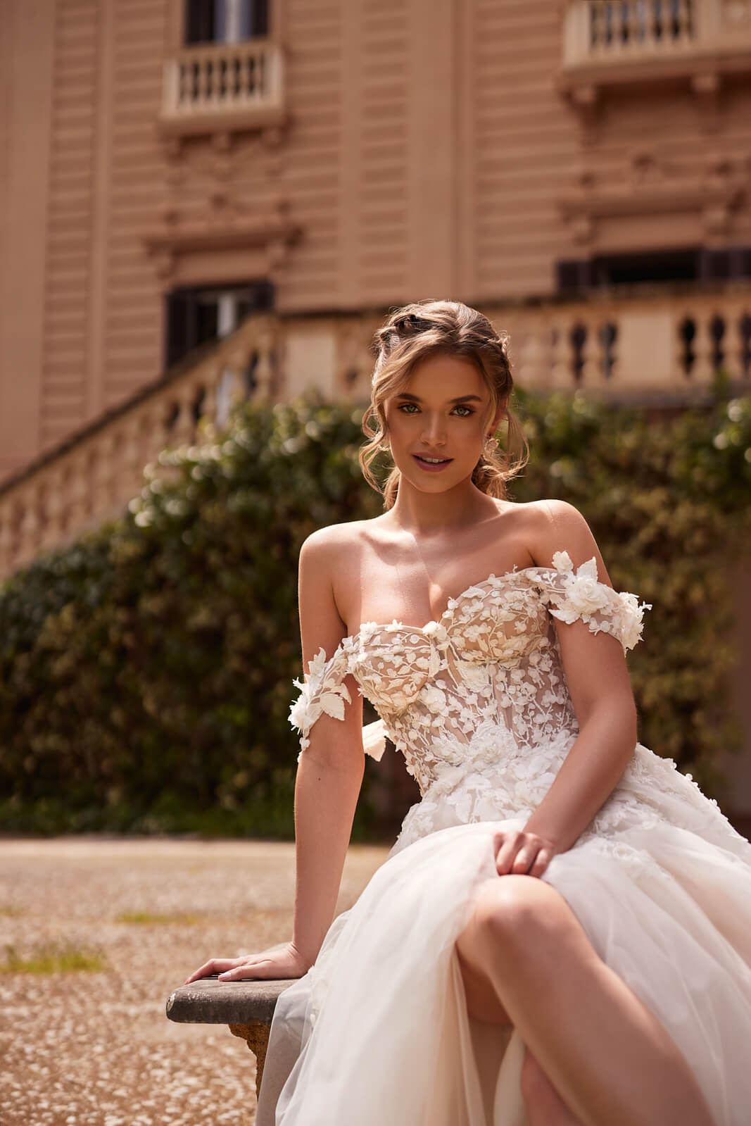 Seated view of Mia, showing floral appliqués around the sweetheart neckline