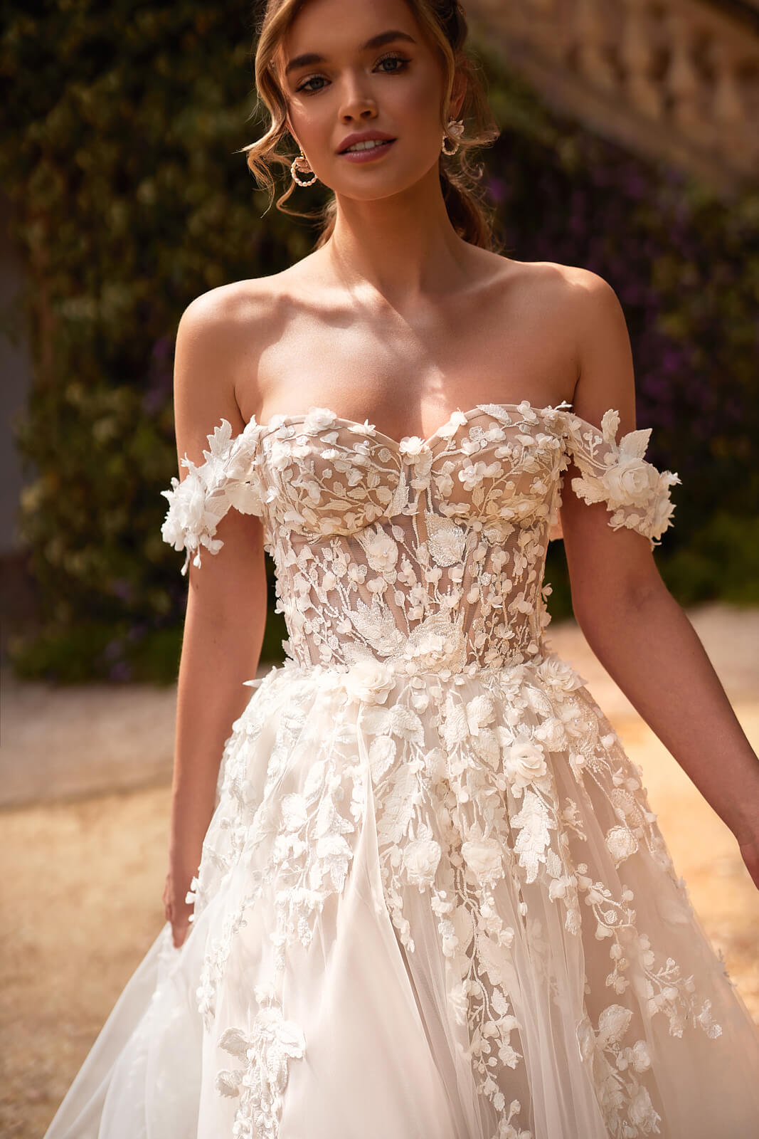 Close-up of Mia with draped shoulder sleeves and raised flowers on the corset