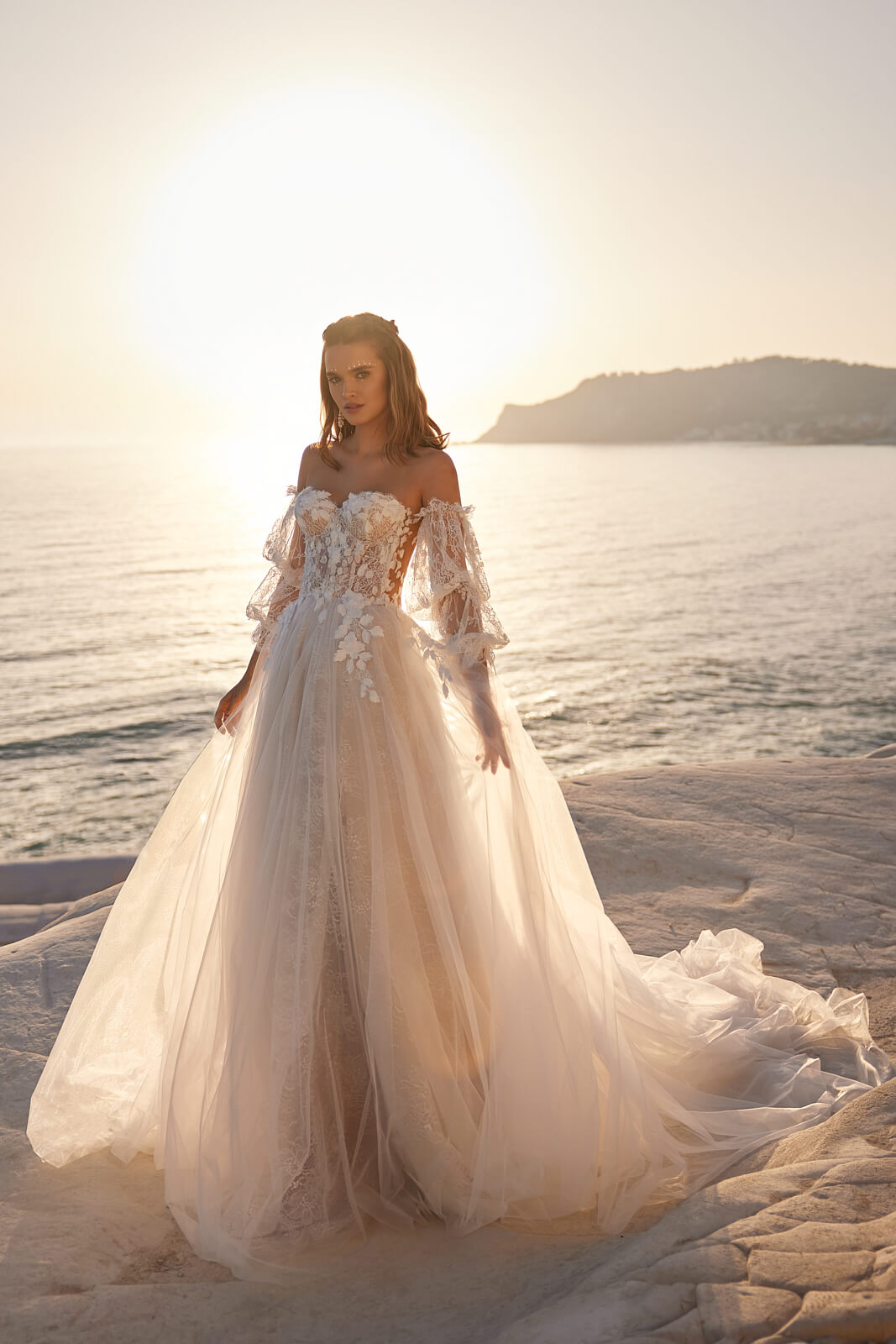 Sievi wedding dress at full length beside the sea, sheer corset above an A-line skirt