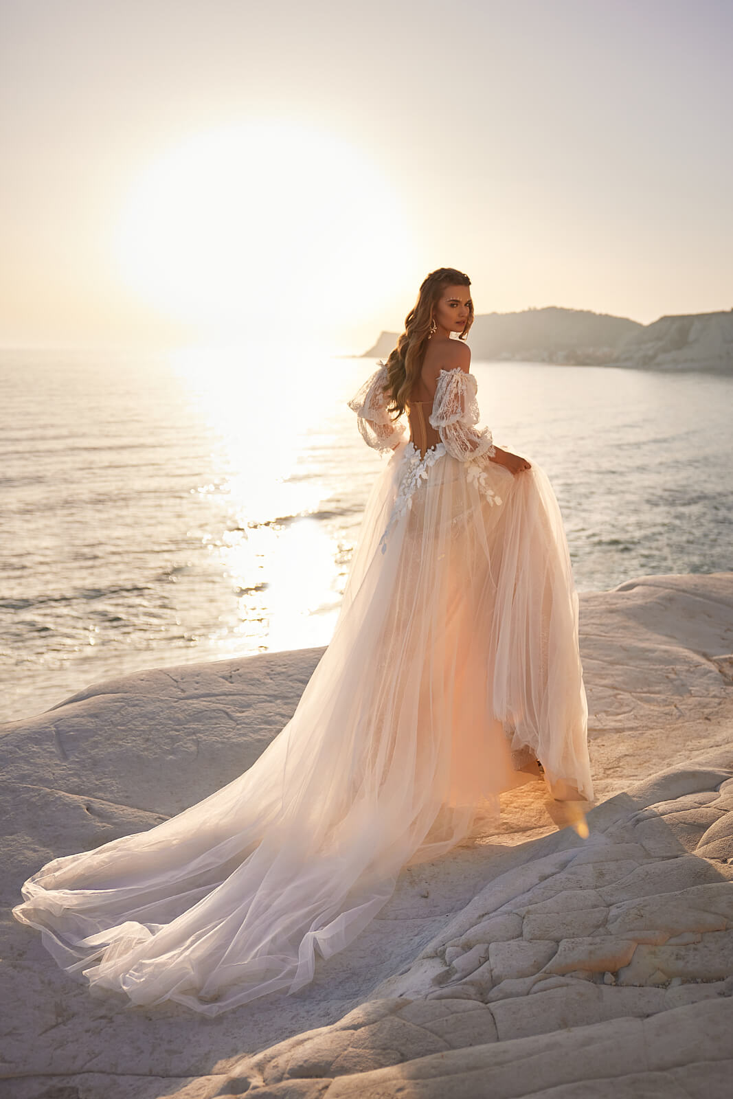 Back view of Sievi, with a tulle train over rocks in the evening light