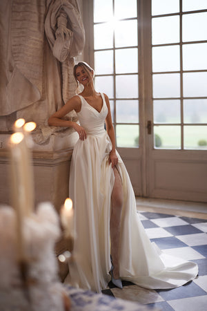 Elvira wedding dress – A-line bridal gown with an open V-neckline and clean draped skirt with a high slit.