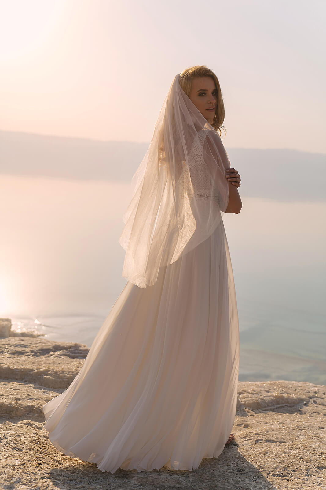 Back view of Regular veil, tulle falling over an A-line chiffon wedding dress