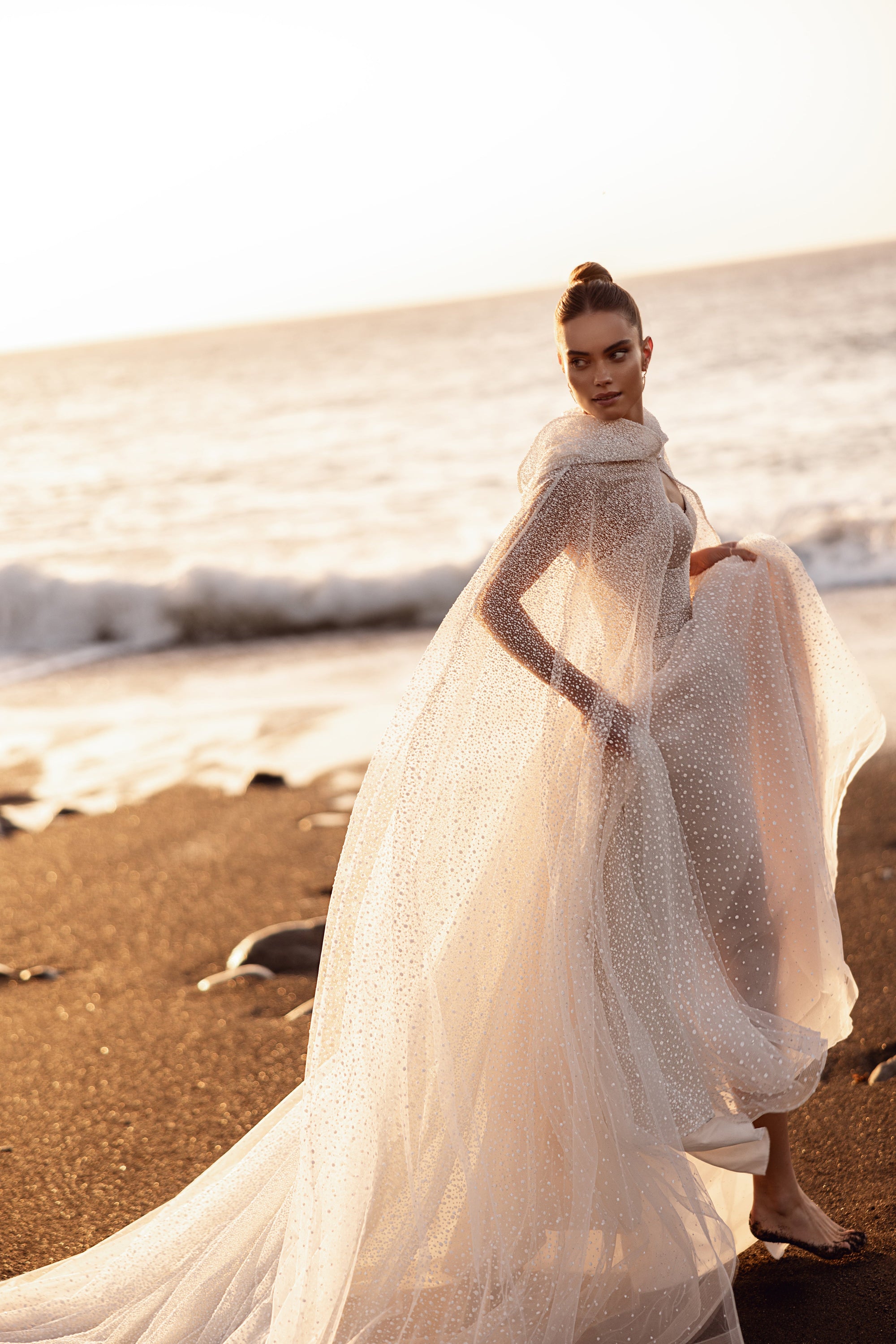 Amira bridal cape with a dramatic flowing tulle train for a fairytale bride look.