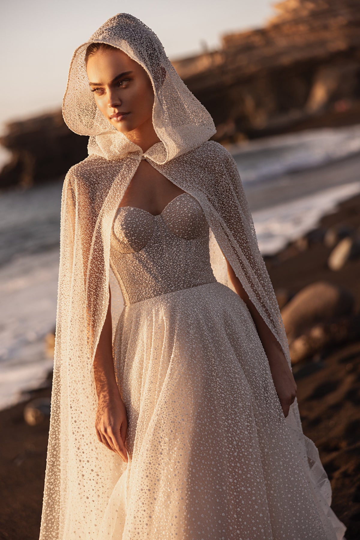 Amira cape worn with the hood up, two long tulle panels falling over an A-line skirt