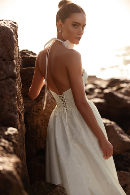 Rear view of the Cholly bridal dress featuring a lace-up back and open neckline, blending grace with allure.