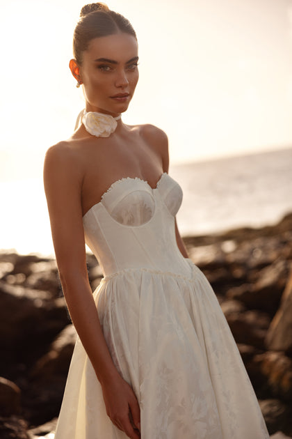 Close view of the Cholly bridal gown with a fitted corset bodice and delicate flower choker, made for a romantic bride.