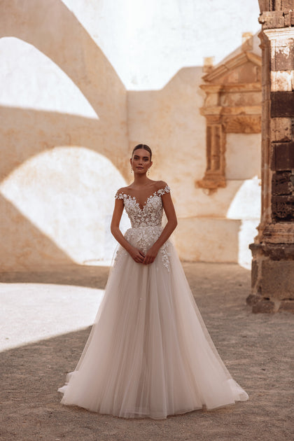 The Andrea bridal dress showcases a low back and lace detailing, offering a graceful and feminine bridal style.