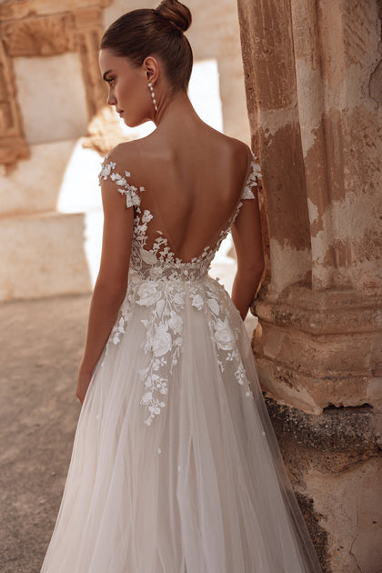 The Andrea bridal gown features a sweeping tulle train and low back for a truly timeless, romantic look.