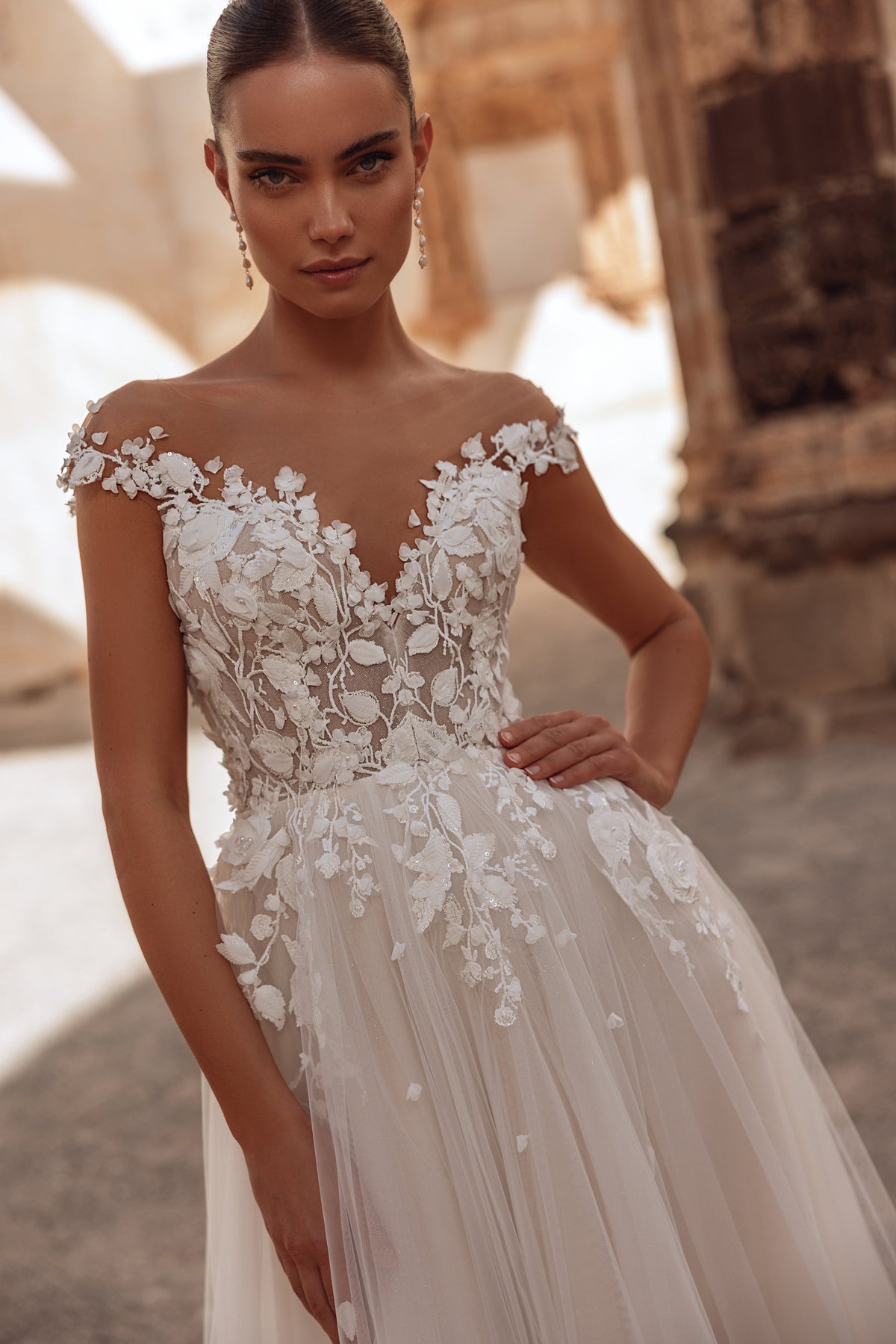 The Andrea wedding dress features a 3D floral lace bodice and flowing tulle skirt for a dreamy, romantic bridal look.