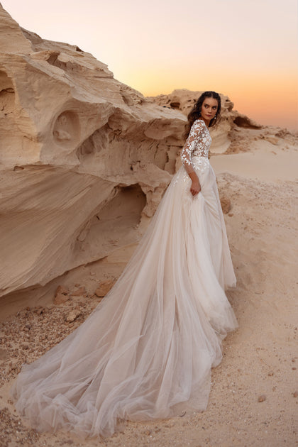 The Armori bridal gown with illusion lace bodice and plunging neckline captures contemporary elegance and soft femininity.