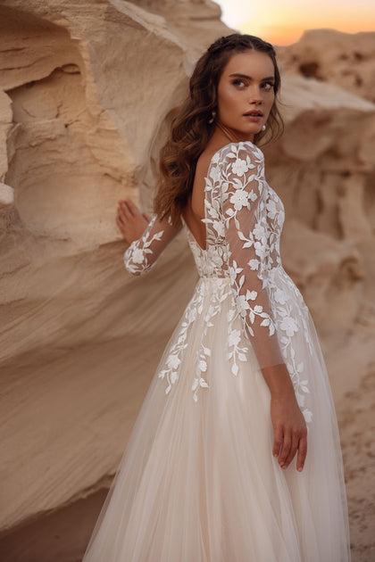 The Armori bridal gown’s open lace back and flowing tulle layers highlight refined elegance and romance.