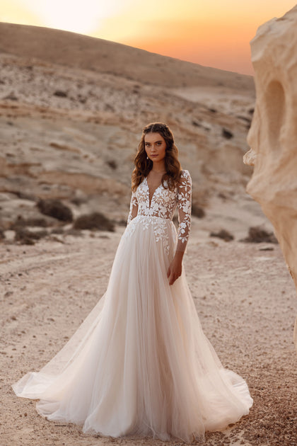 The Armori bridal dress with a plunging V-neck and lace sleeves exudes soft elegance and modern romance.
