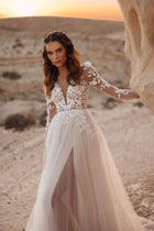 The Armori bridal gown features a flowing tulle train and floral lace top, captured in the glow of a desert sunset.