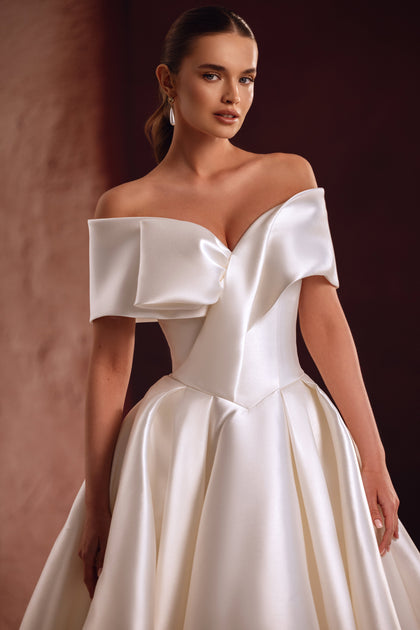 The Avin bridal gown close-up reveals the refined satin finish and elegant off-shoulder draping.