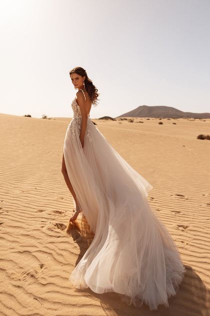 The Aviva bridal dress with a soft tulle train and elegant slit brings fluidity and charm to a modern bridal silhouette.